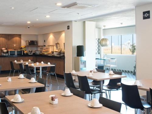 a restaurant with tables and chairs and a kitchen at City Express by Marriott Santiago Aeropuerto in Santiago