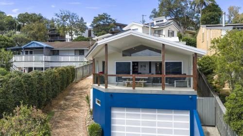 a house with a blue and white garage at For - Resters in Wamberal