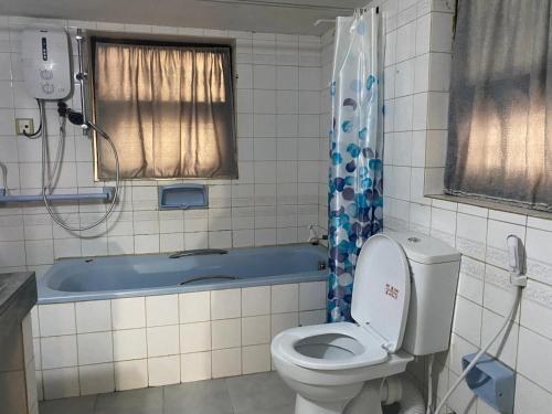 a bathroom with a toilet and a bath tub at MercuryFM 103 Guest House - Colombo 3 in Colombo