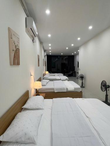 a row of four beds in a room at Tie Homestay in Dong Hoi