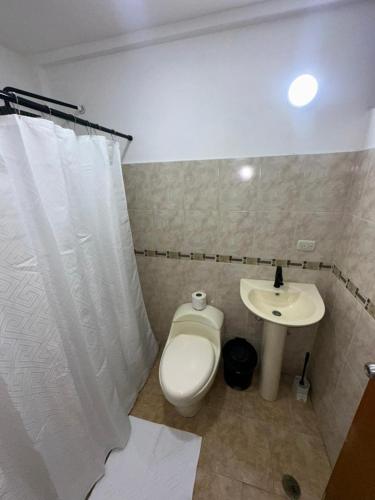 a bathroom with a toilet and a sink at Casa Vacacional in Tucacas