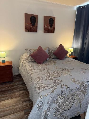 a bed in a bedroom with three pictures on the wall at 2108 Depto a 15 minutos del Aeropuerto frente mall in Santiago