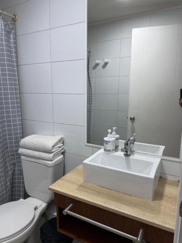 a bathroom with a sink and a toilet and a mirror at 2108 Depto a 15 minutos del Aeropuerto frente mall in Santiago