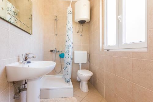a bathroom with a sink and a toilet and a window at Apartment Avoca in Cavtat