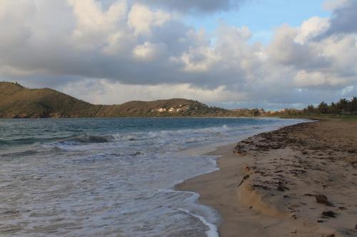 a beach with the ocean and mountains in the background at Villa Sans Souci in Vieux Fort