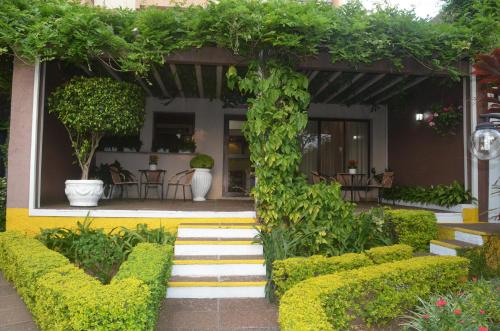 a garden with green plants and stairs in front of a building at River Hotel in Uruguaiana