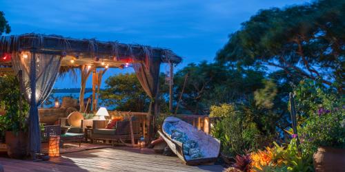 a wooden deck with a gazebo and a couch at Pousada Enseada das Garças in São Pedro da Aldeia