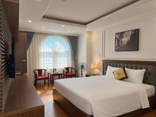 a bedroom with a large white bed and a window at Mercy Hotel in Hanoi