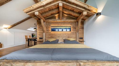 a large bed in a room with wooden ceilings at Ferienwohnung Schmickhof in Gaißach