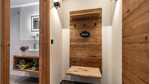 a bathroom with a wooden door and a sink at Ferienwohnung Schmickhof in Gaißach