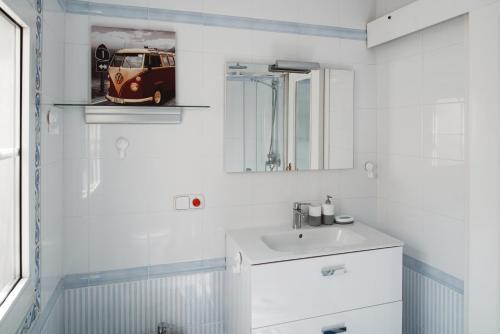 Un baño blanco con lavabo y espejo. en Atico Atalaya, en Alicante