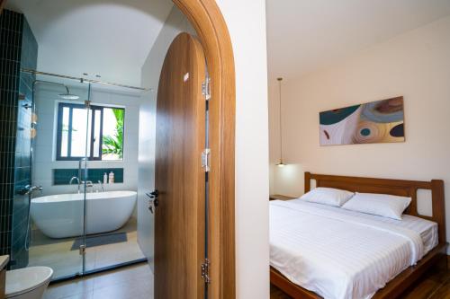 a bedroom with a bed and a bath tub and a sink at AT Homestay Huế in Thôn Lại Thê