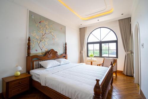 a bedroom with a large bed and a window at AT Homestay Huế in Thôn Lại Thê