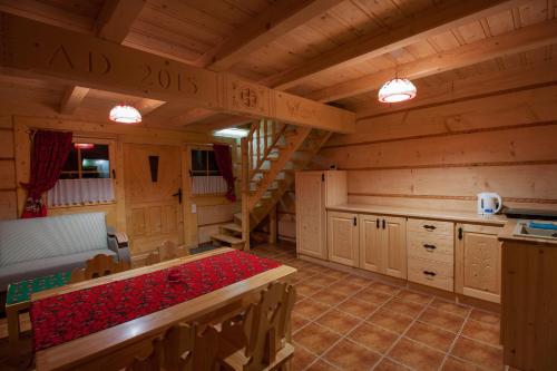 una cocina con mesa y escaleras en una cabaña en Domek na Górkach en Krościenko