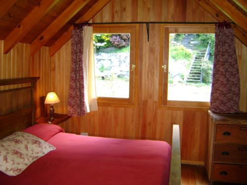 a bedroom with a pink bed and a window at El Recodo in San Martín de los Andes