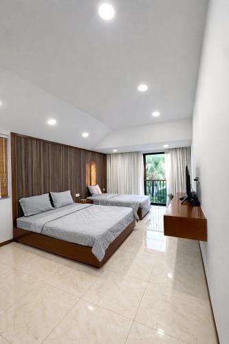 a bedroom with two beds and a television in it at Luxury villa Phu Quoc in Phú Quốc