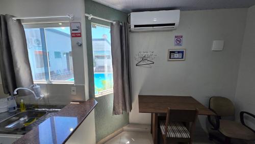 a kitchen with a sink and a table and a window at Pousada Marques Floripa in Florianópolis
