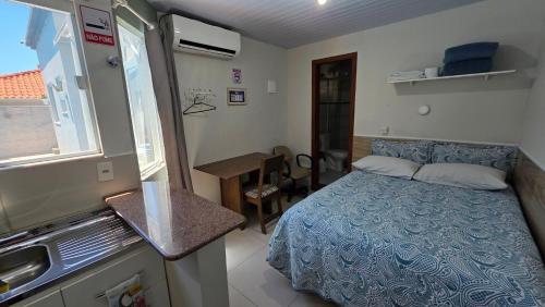 a small bedroom with a bed and a sink in it at Pousada Marques Floripa in Florianópolis