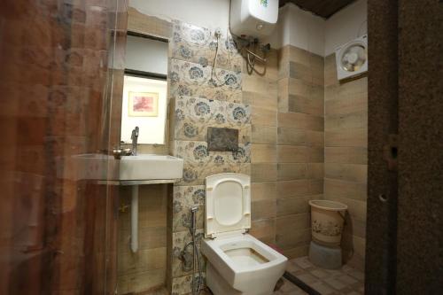a bathroom with a toilet and a sink at Staykart Lotus in Bhilwara