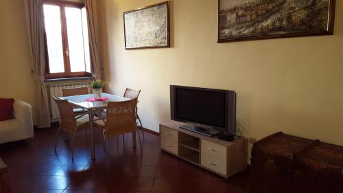 ローマにあるナヴォーナ スタジオ アパートメントのリビングルーム(テレビ、テーブル、椅子付)