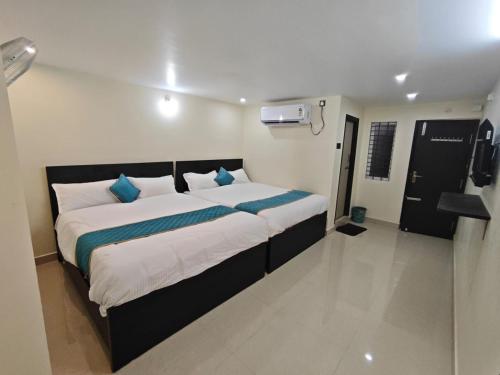 a bedroom with a large bed with blue pillows at HOTEL VAJRA Grand in Tirupati