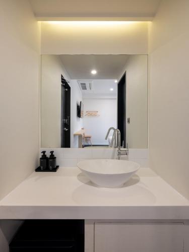 a white bathroom with a sink and a mirror at Unplug Anguk in Seoul