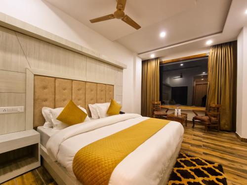 a bedroom with a large bed with yellow pillows at Hotel Mistwood in Banikhet
