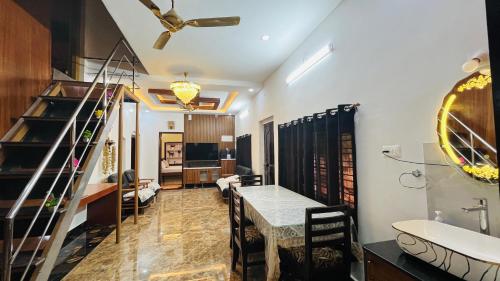 a living room with a dining room table and a bathroom at Odrine's abode - Udupi in Kalyānpur
