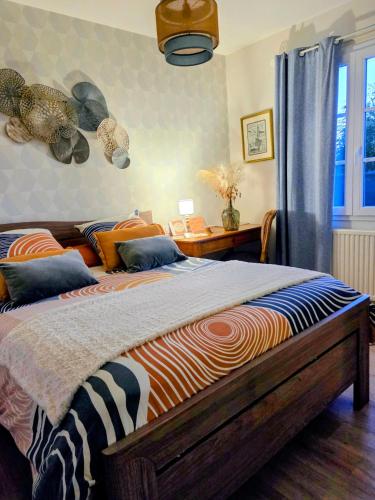 a bedroom with a large bed and a desk at chambre d'hôte chez Mimidid in Le Landreau
