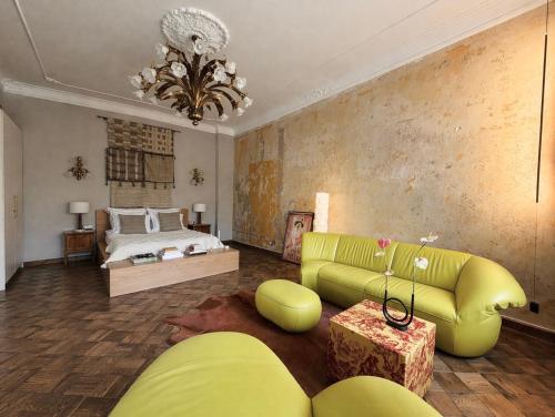 a living room with a yellow couch and a bed at Maison Stefana Rynek in Rzeszów