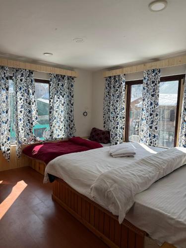 a bedroom with two beds and a window at Mughal resort pahalgam in Pahalgām
