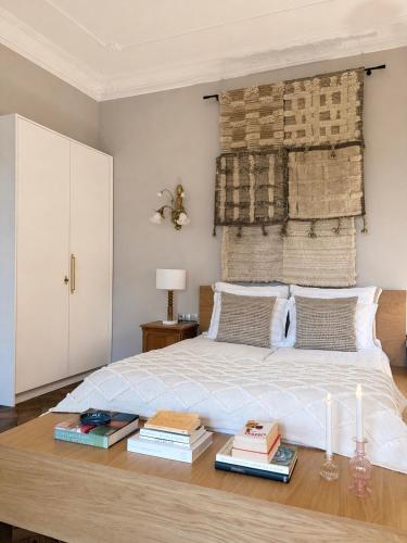 a bedroom with a bed with books on a wooden table at Maison Stefana Rynek in Rzeszów