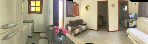 een woonkamer met een bank en een stoel in een kamer bij Apartamento em Residencial Riviera in Florianópolis