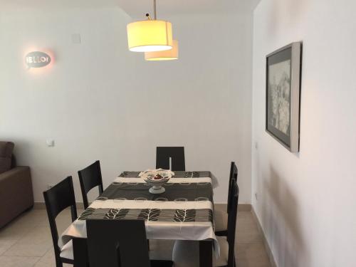 a dining room with a table and chairs and a lamp at Saval Spa Aqquaria Family Complex in Salou