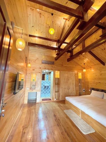 a bedroom with wooden walls and a bed in a room at Homestay Gió Mộc !! in Làng Môn