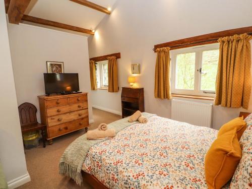 a bedroom with a bed and a tv and a window at Two Town End in Penrith
