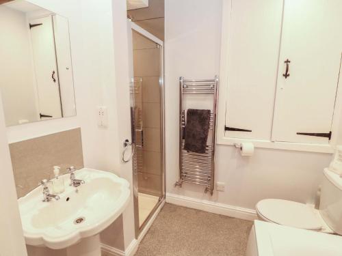 a white bathroom with a sink and a shower at Two Town End in Penrith