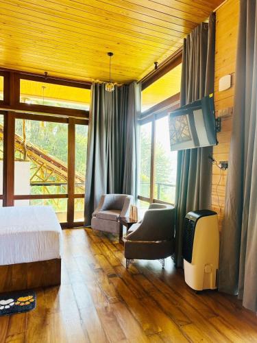 a bedroom with a bed and a couch and a chair at The Chill Heights Ramboda in Ramboda