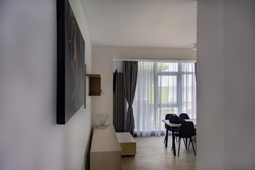 a living room with a table and chairs and a window at Apartament Alezzi in Năvodari