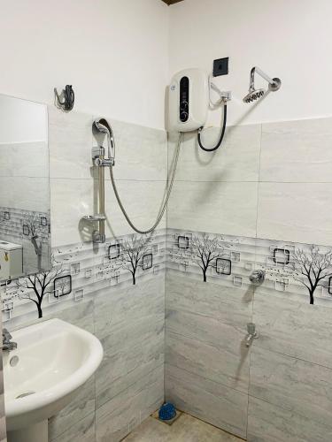 a bathroom with a shower and a sink at Sawmya Guest House in Randeniya