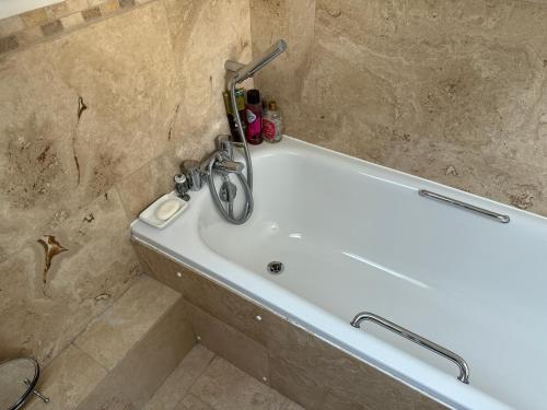 a bath tub in a bathroom with a sink at Silsoe Cottage B&B - Woodland View Room in Silsoe