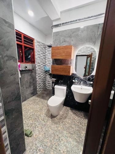 a bathroom with a toilet and a sink and a mirror at K won Villa in Busse