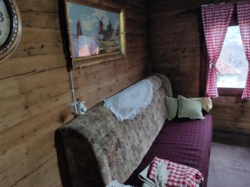 a living room with a couch in a log cabin at Milov konak in Berane