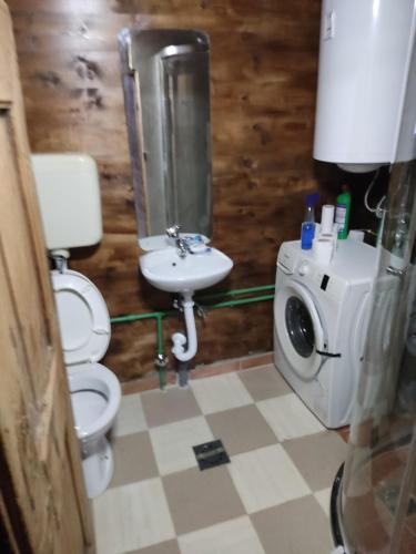 a bathroom with a toilet and a sink and a washing machine at Milov konak in Berane