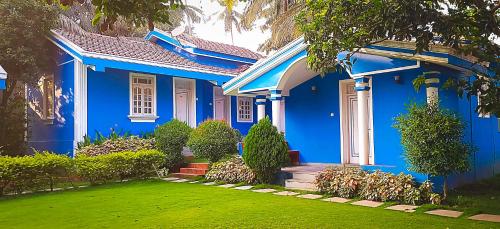a blue house with a lawn in front of it at SUSAGADE in Vagator