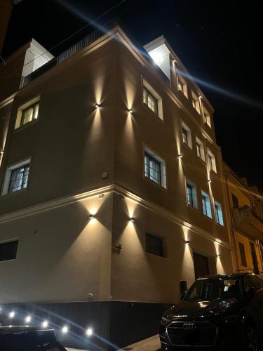 a building with lights on the side of it at night at Strettorooms in Villa San Giovanni