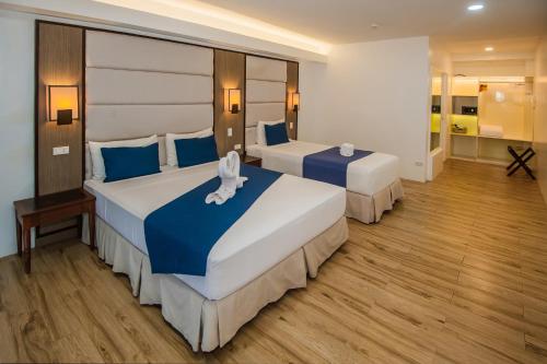 a hotel room with two beds with blue pillows at Panja Resort Palawan in Puerto Princesa City