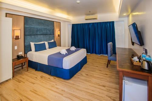 a hotel room with a large bed and a desk at Panja Resort Palawan in Puerto Princesa City