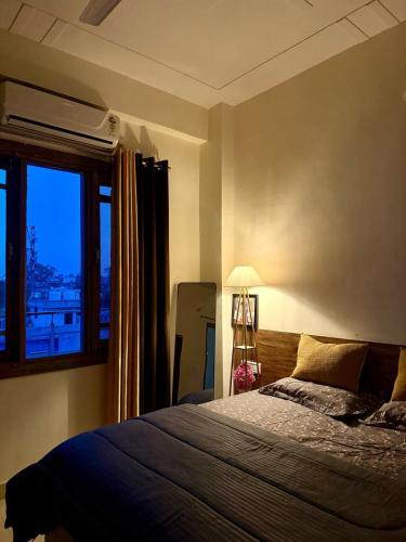 a bedroom with a large bed and a window at Bunkyard rishikesh in Rishīkesh