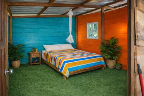 a bed in a room with a blue wall at San Blas island cabins in Waisalatupo